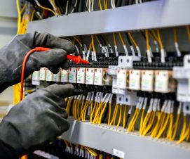 Electrical engineer using digital multi-meter measuring equipmen